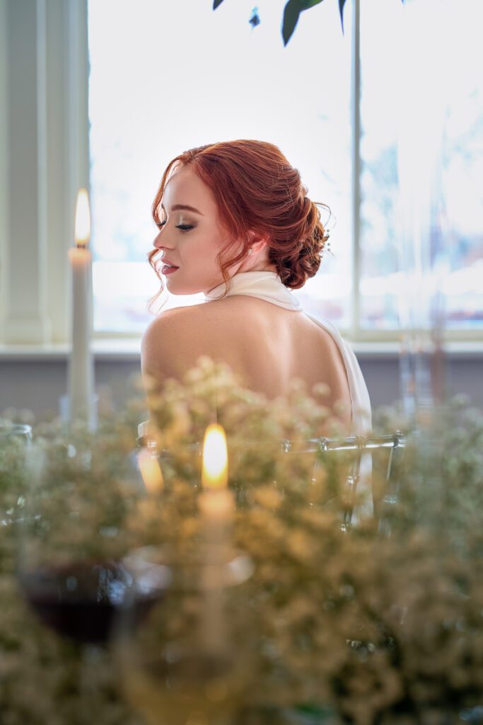 bride with red hair in candle lit baby breath room