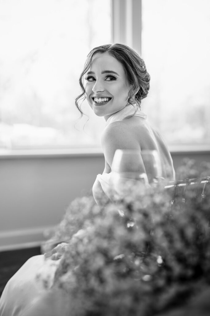 bride laughing over back shoulder with wine glass and baby breath