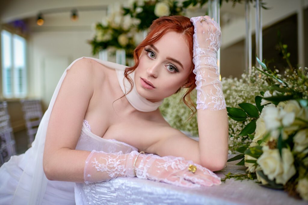 romantic redhead bride laying on baby breath table spread with lace gloves