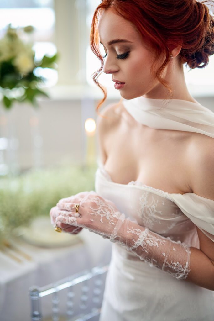 bride adjusting ring on lace gloves with red hair