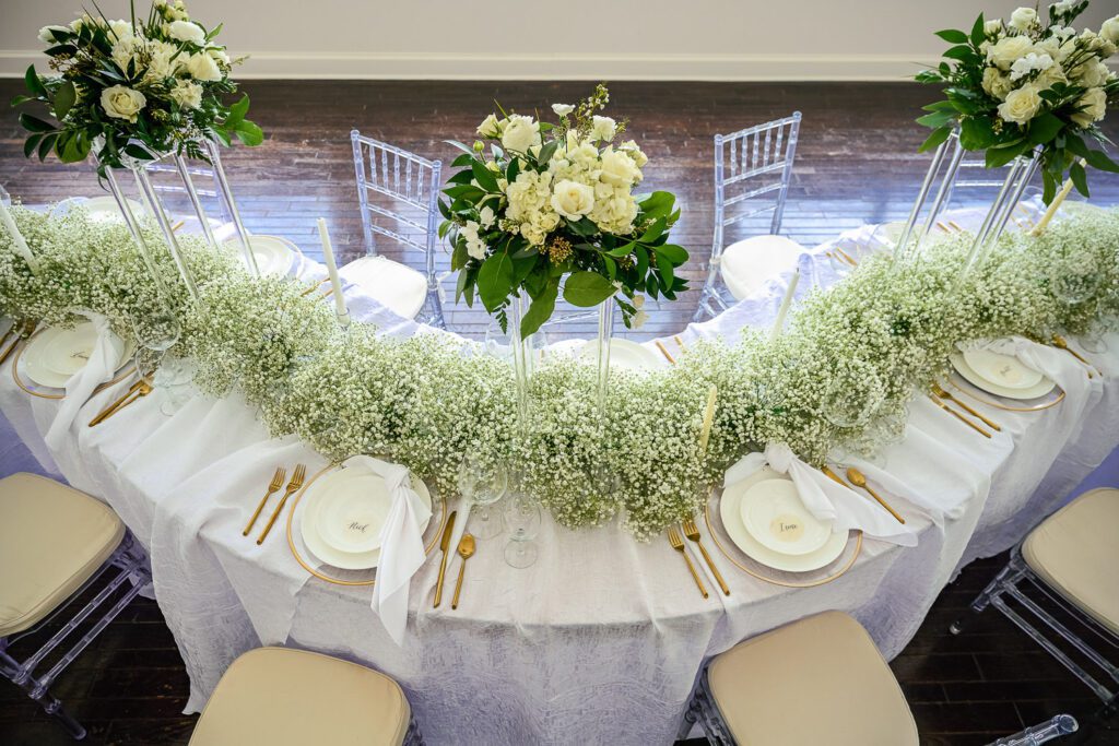 s curve table with baby breath and place settings for light and airy wedding