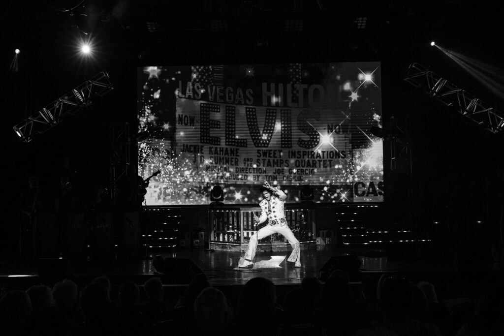 Elvis presley tribute artist Dean Z takes a karate pose during performance 
