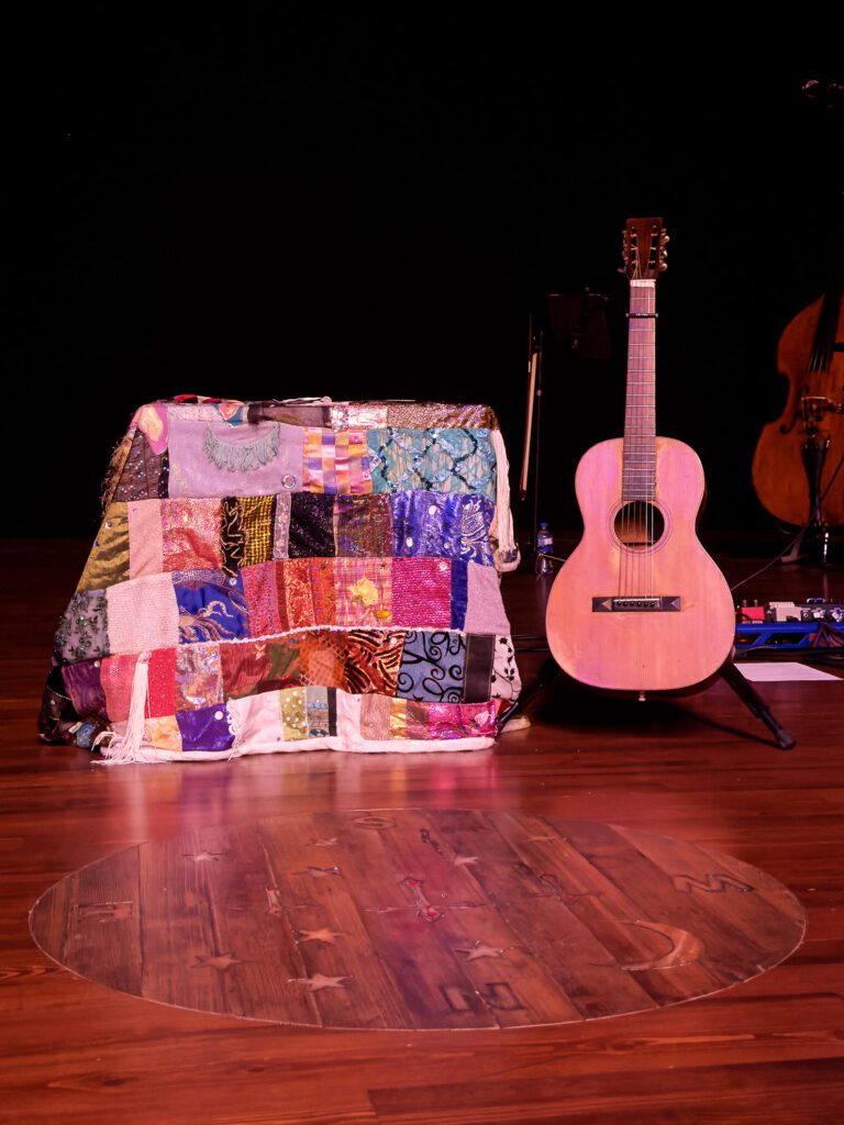 Dolly Parton's guitar and coat of many colors quilt at the Ellis Theater.
