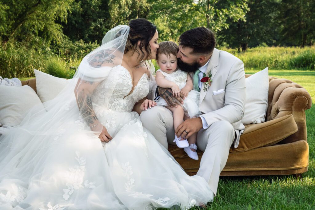 Megan and Hunter Murray sit on couch with their daughter