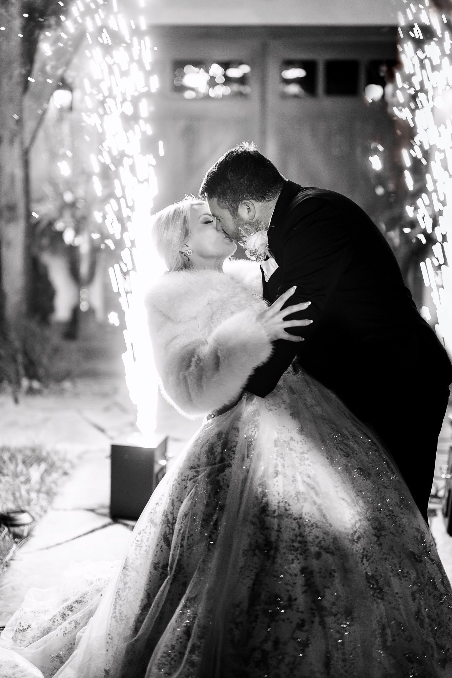 bride and groom kiss in front of cold sparks in the air