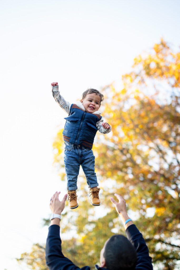 a father tosses small child in air