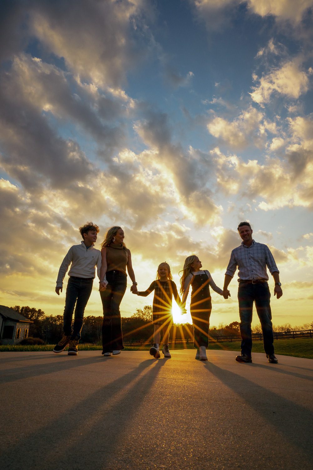 family walks together with clouds and sun rays