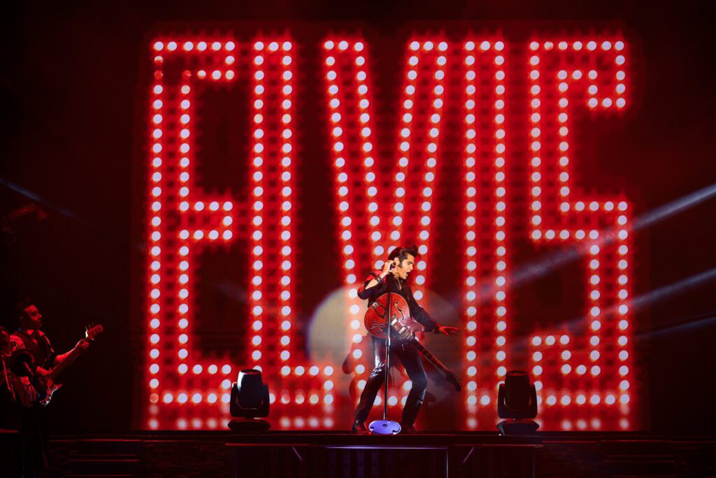 Dean Z performs as Elvis Presley at the Clay Cooper Theatre in Branson MO in front of large red elvis sign