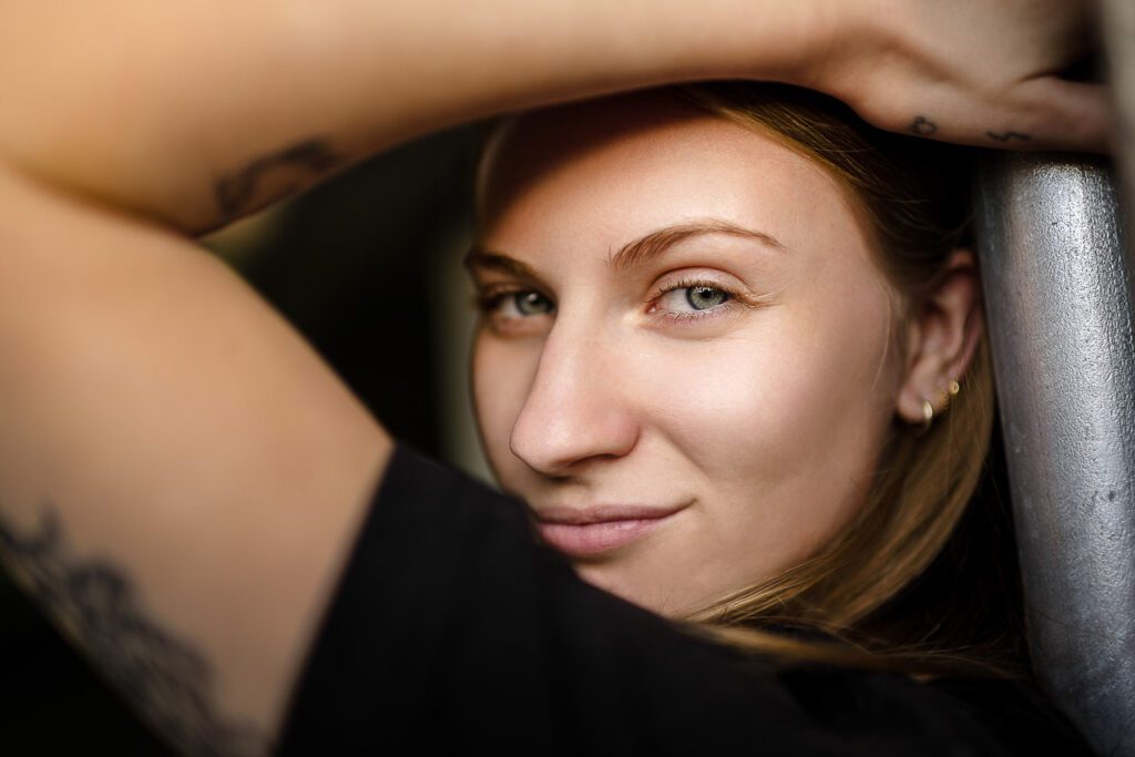 senior girl looks at camera through her bent arm