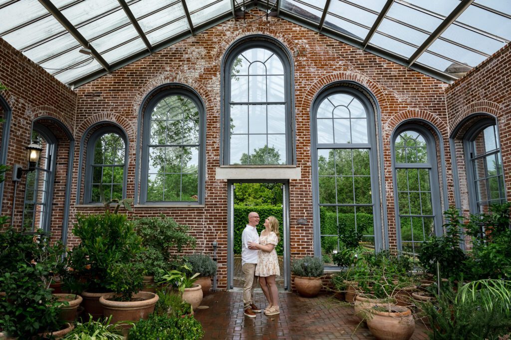 couple stand in green house at St louis botanical gardens during engagement shoot