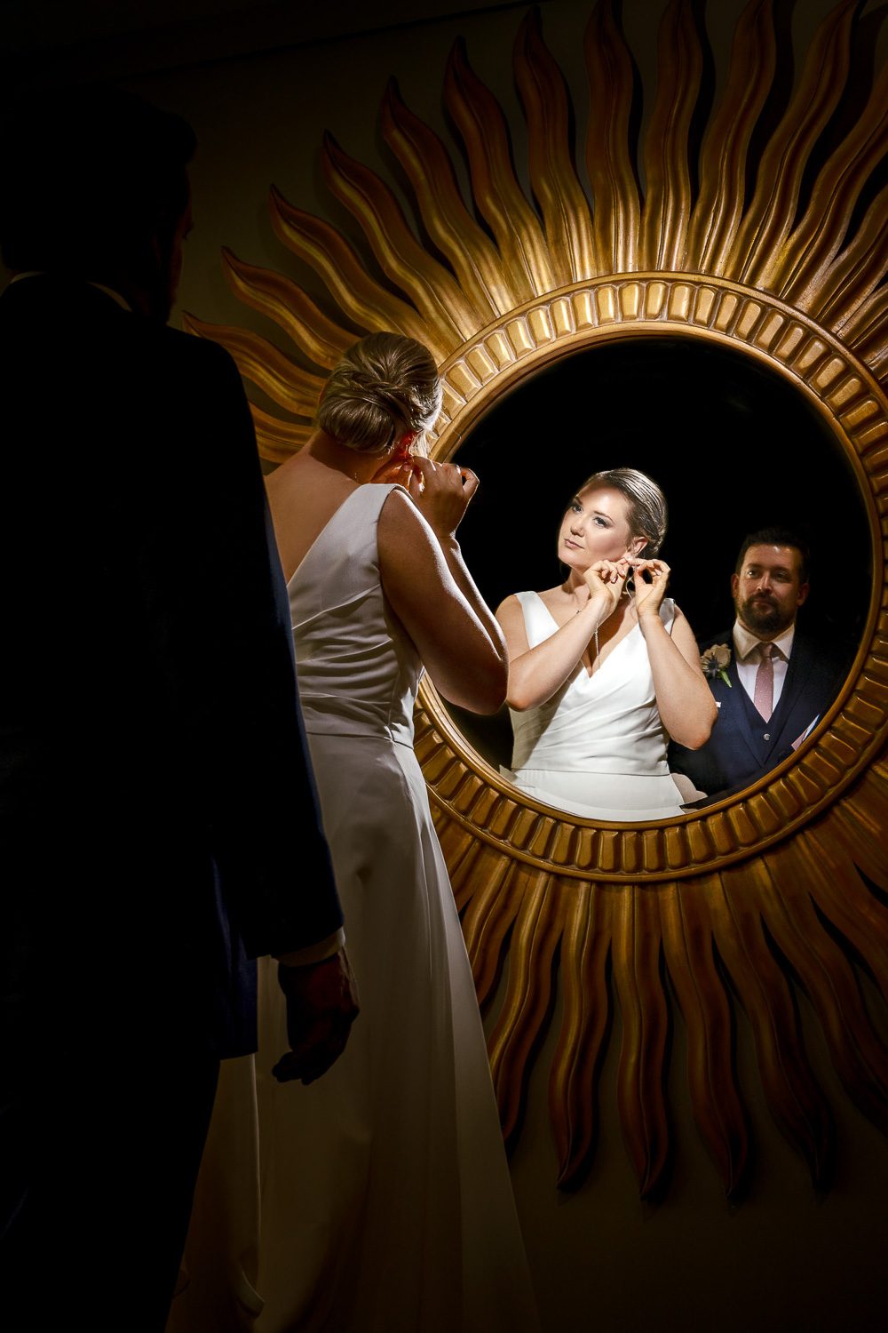 bride and groom look in golden mirror