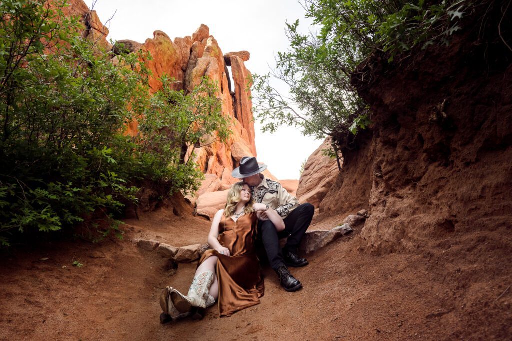 couple sit together wearing western clothing at the garden of the gods in colorado springs colorado scott shannon schaefer