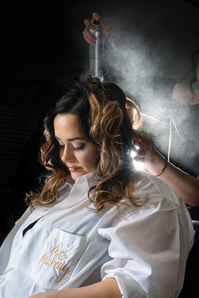 bride getting hair done with hairspray