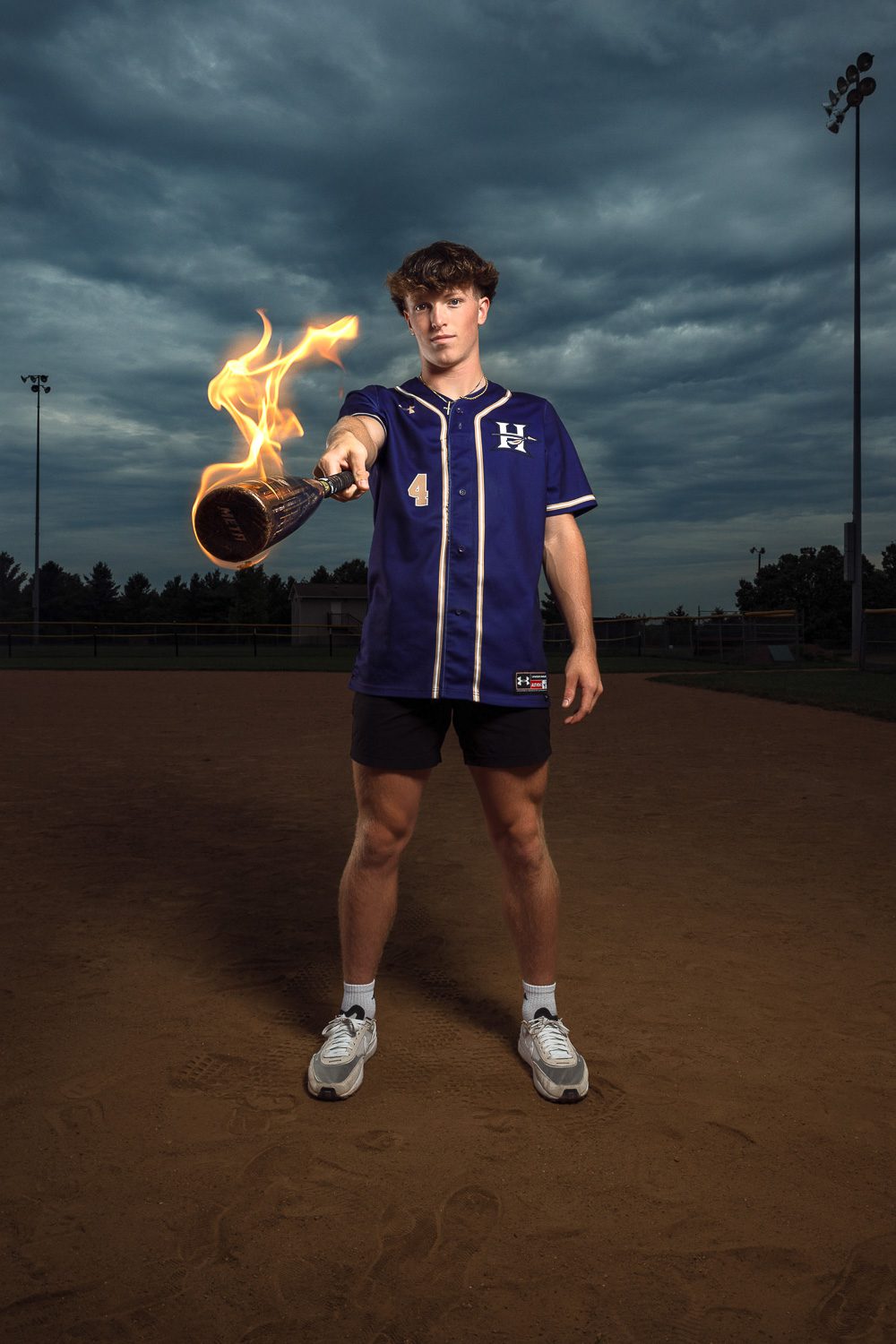 hallsville senior baseball player guy holds bat with fire