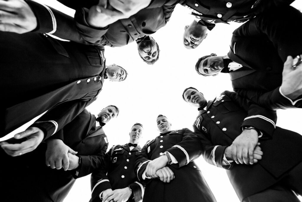A circle of Army men soldiers on wedding day looking down at camera