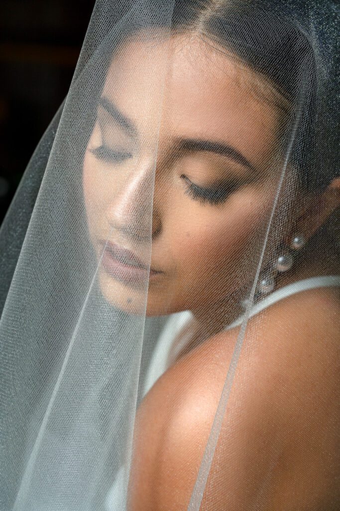 bride looks down through veil