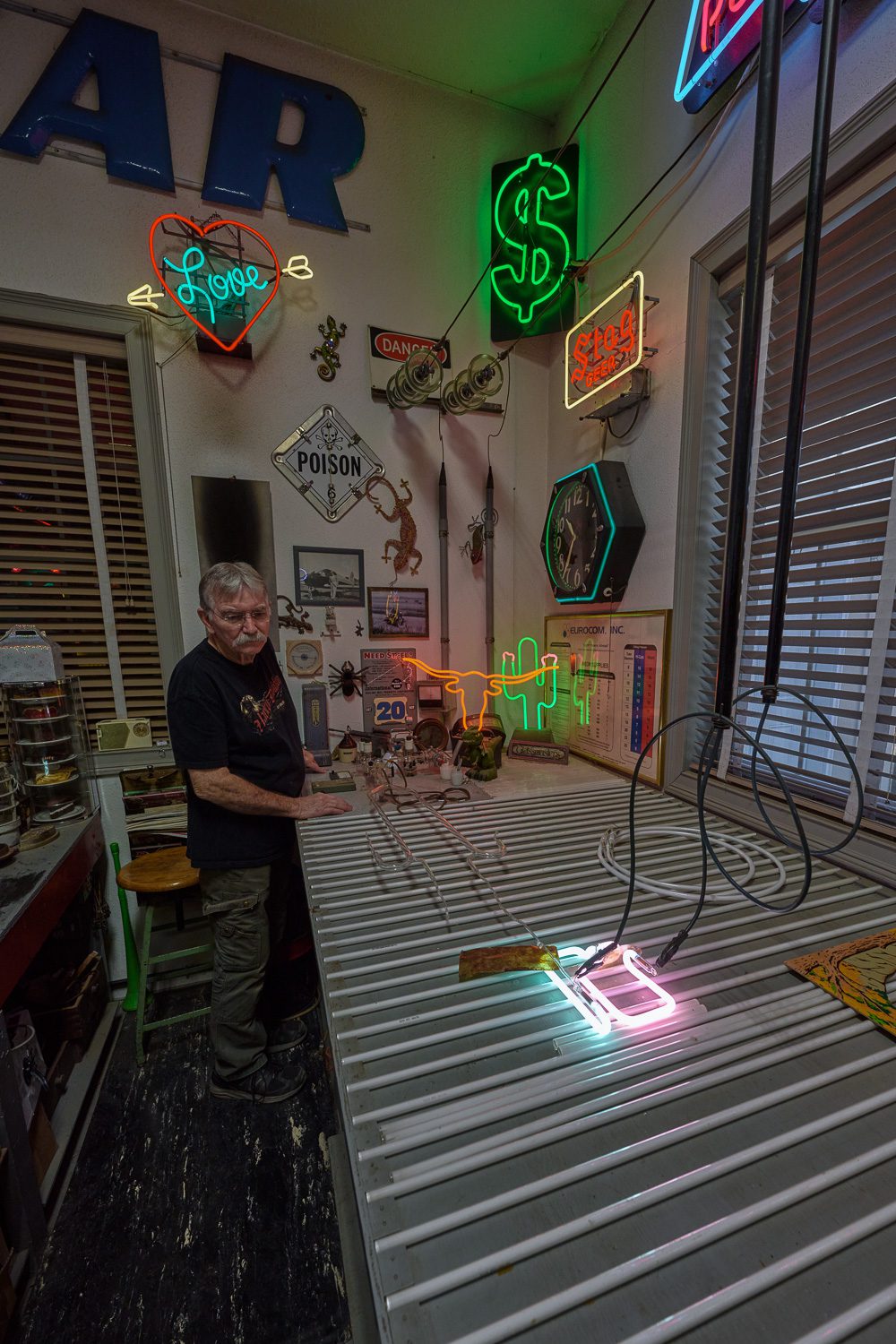A new neon sign piece is hooked up to electricity and heated to 600 degrees.
