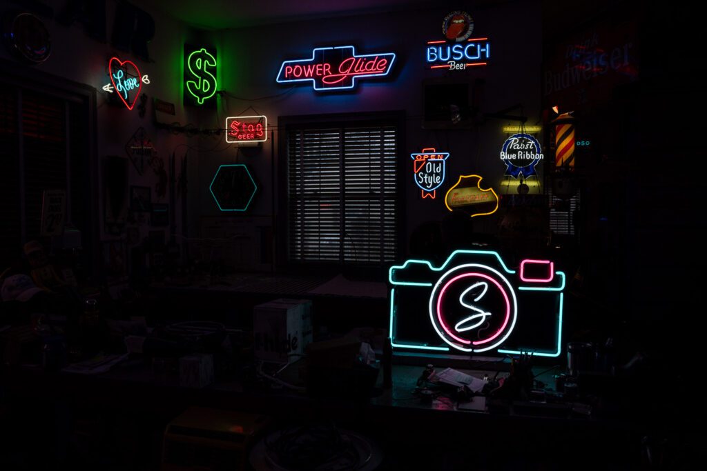 a room full of neon signs including a schaefer photography camera sign