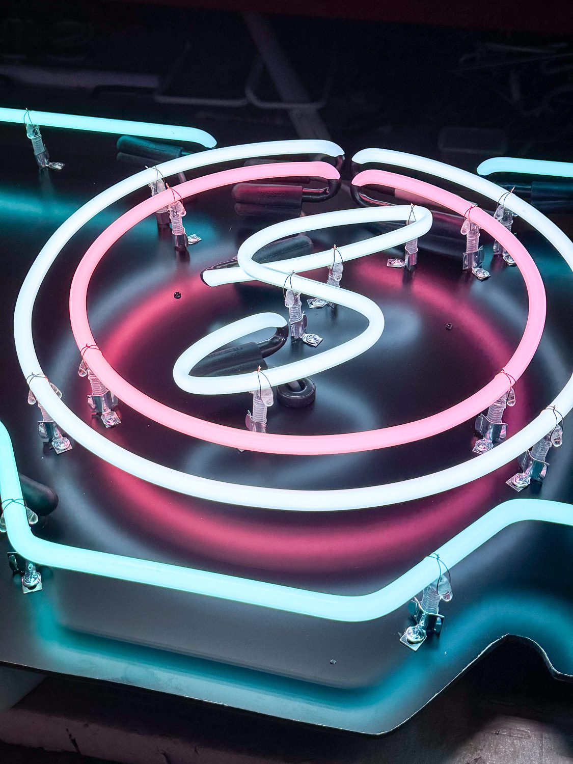 Neon glass closeup showing pink, white and turquoise glass tubing