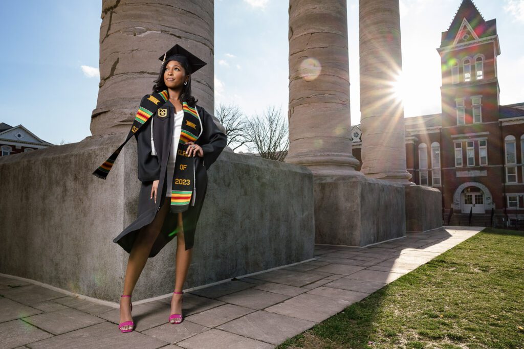 senior woman wearing cap and gown with Kente Stoll