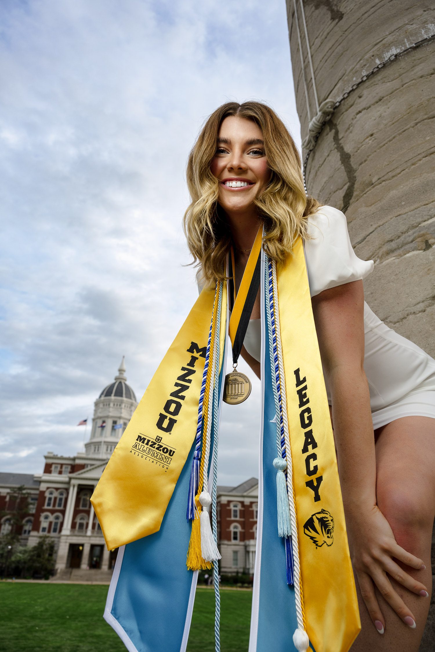 Senior brunette girl wearing stolls in front of Jesse Hall