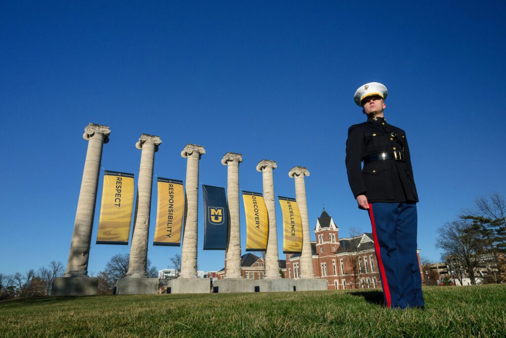 Marine Senior stands at attention in front of the Mizzou Columns