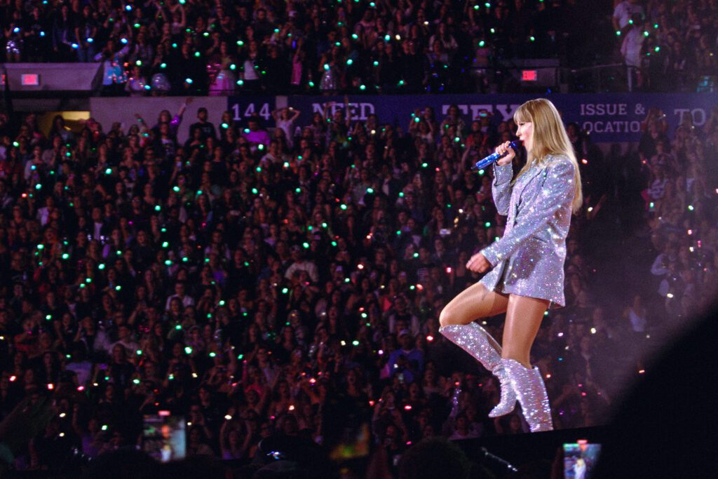 taylor swift walking in boots with crowd in background