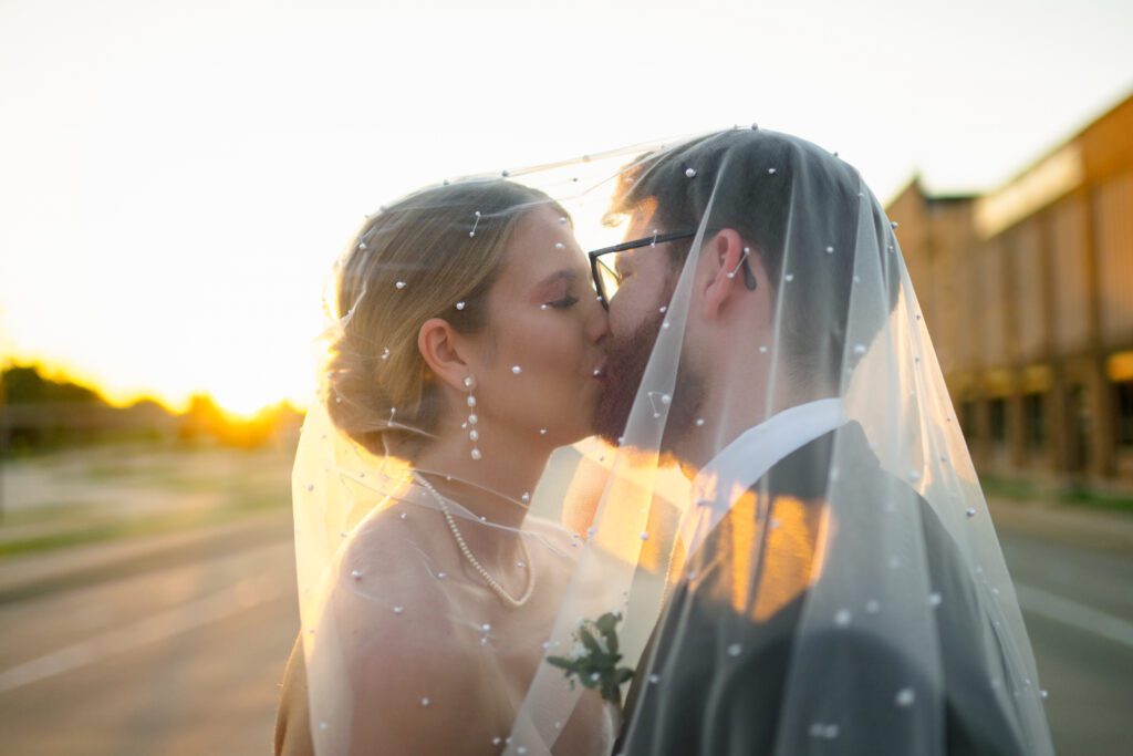 bride and groom kiss under veil